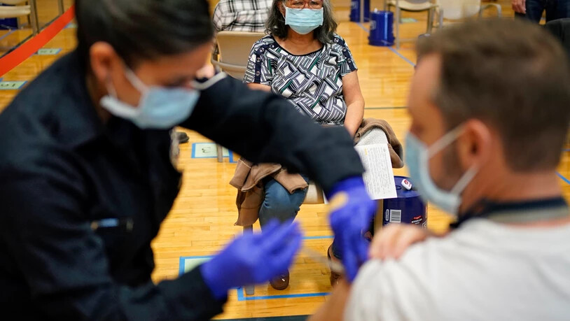 ARCHIV - Menschen erhalten den COVID-19-Impfstoff an einer Impfstelle in Las Vegas. Foto: John Locher/AP/dpa