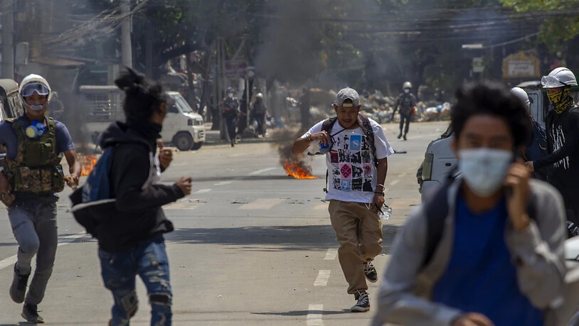 Demonstrantenlaufen vor der Polizeidavon. Seit Beginn der Proteste gegen den Militärputsch in Myanmar sind bei den brutalen Auseinandersetzungen viele zu Tode gekommen. Foto: Uncredited/AP/dpa