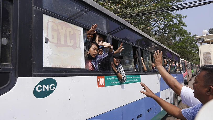 Festgenommene Demonstranten winken Menschen, während sie in einem Bus sitzen, der aus dem Insein-Gefängnis kommt und sie zu einem ungenannten Ort transportieren wird. Foto: Uncredited/AP/dpa