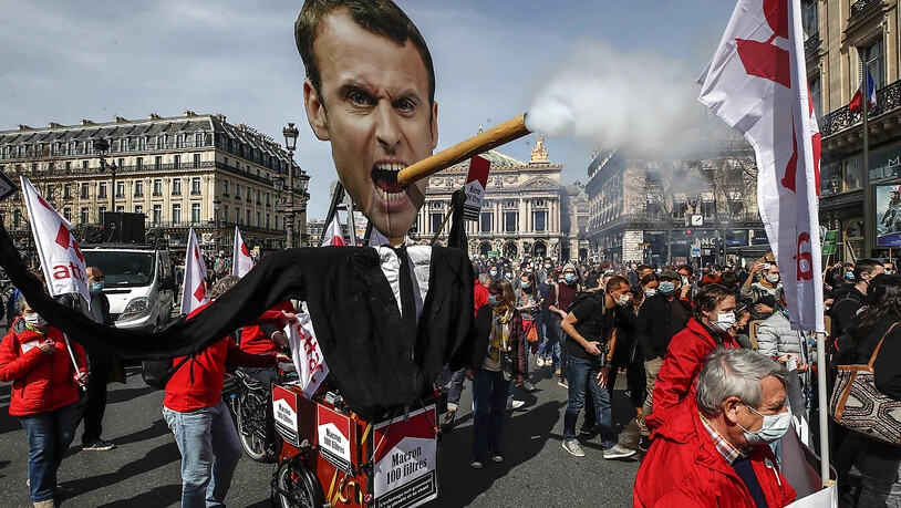 dpatopbilder - Demonstranten nehmen in Paris mit einem Plakat, das den französischen Präsidenten Macron mit einer rauchenden Zigarre darstellt, an einer Kundgebung für eine beherztere Klimapolitik teil. Foto: Michel Euler/AP/dpa