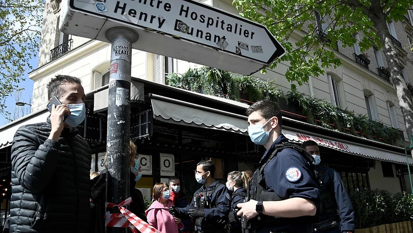 Polizisten sperren das Gebiet um das Krankenhaus Henry Dunant ab. In Paris ist mindestens ein Mensch in der Nähe des Krankenhauses durch Schüsse getötet worden. Foto: Anne-Christine Poujoulat/AFP/dpa