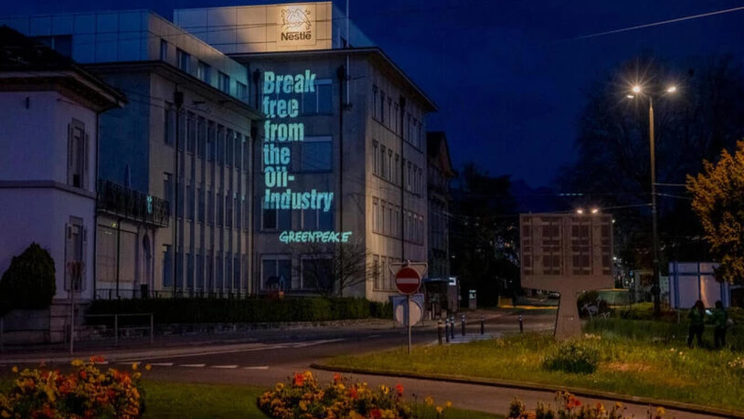 Die Umweltorganisation Greenpeace hat ihre Forderungen an die Fassade eines Nestlé-Betriebes in La-Tour-de-Peilz projeziert. (Bild: Greenpeace)