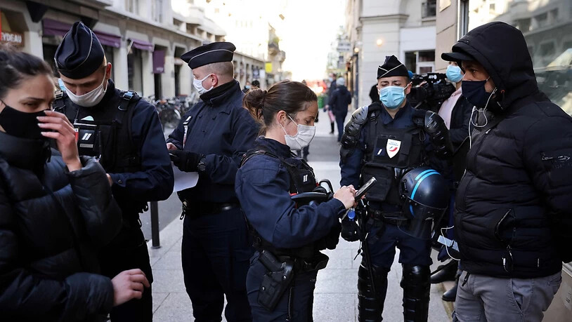 Polizisten kontrollieren Ausweise von Passanten in Paris. Foto: Thomas Coex/AFP/dpa