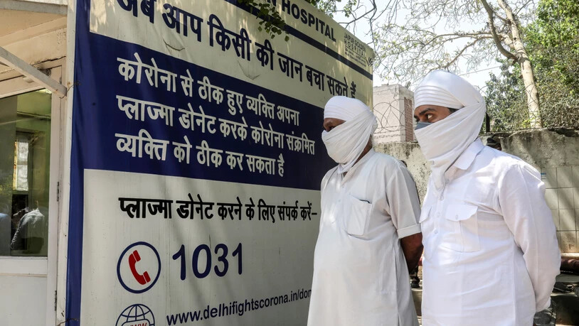 Angehörige von Verstorbenen warten vor dem Jaipur Golden Krankenhaus in Neu Delhi. Foto: Naveen Sharma/SOPA/ZUMA/dpa