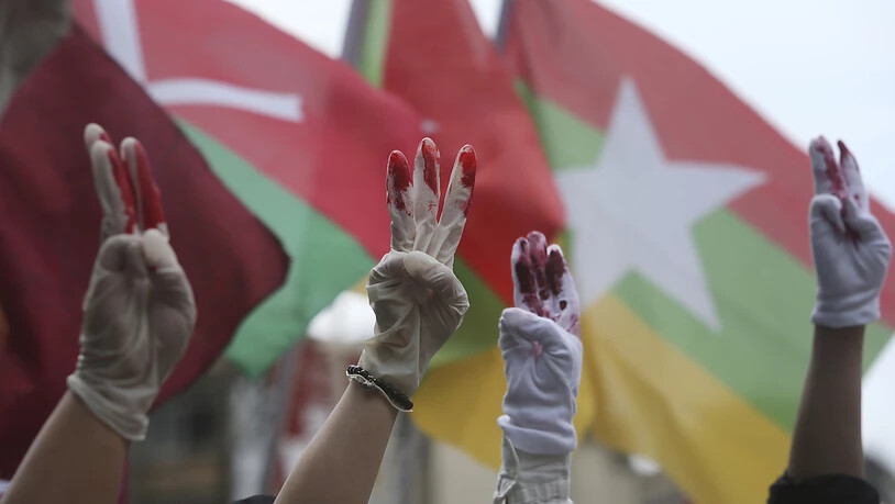 Myanmarische Demonstranten die in Taiwan leben, tragen rot bemalte Handschuhe und zeigen den symbolischen Drei-Finger-Gruß bei einem Protest gegen das Militärregime in Myanmar.(Symbolbild) Foto: Chiang Ying-Ying/AP/dpa
