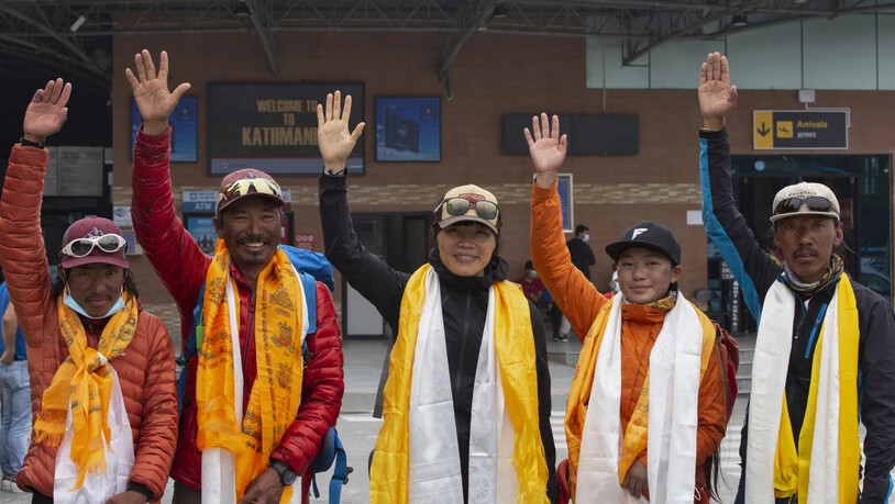 Tsang Yin-hung (M) aus Hongkong winkt während einer Pressekonferenz anlässlich ihres aufgestellten Rekordes für den Aufstieg des Mount Everest. Foto: Bikram Rai/AP/dpa