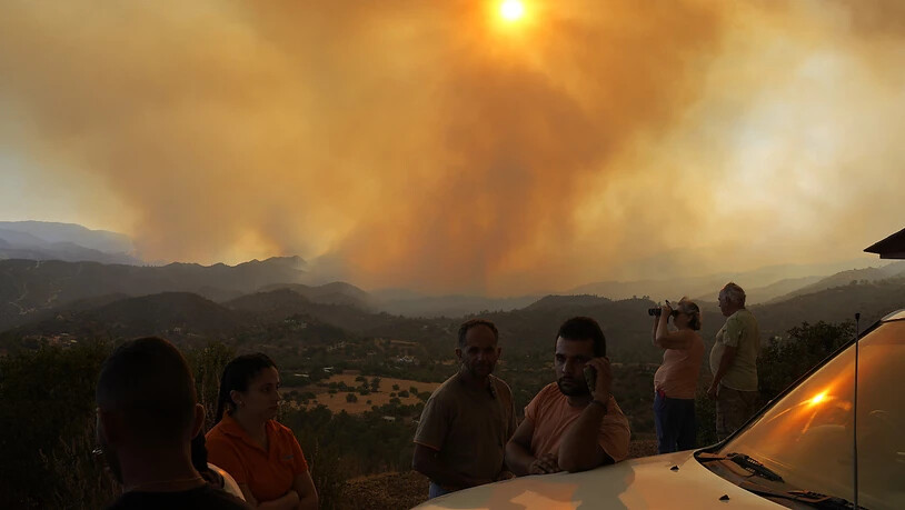 Anwohner beobachten ein Feuer in der Bergregion von Larnaca. Foto: Petros Karadjias/AP/dpa