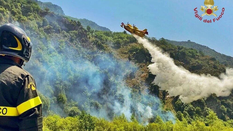 HANDOUT - Ein Löschflugzeug ist in der italienischen Region Kalabrien im Einsatz. Die Region gehört zu den am stärksten von den Waldbränden betroffenen Regionen. Der Präsident von Kalabrien, Nino Spirlì, hatte am Samstag bereits Unterstützung aus Rom…