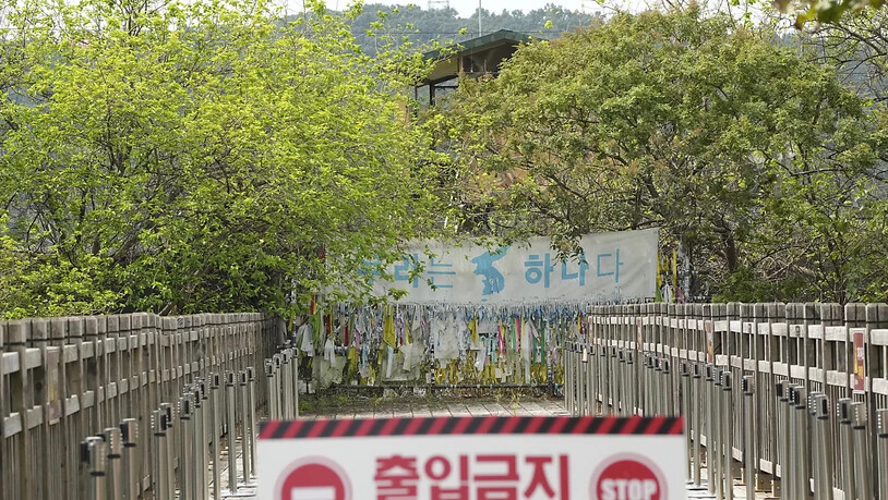 Ein Banner und Bänder, die hoffnungsvolle Botschaften über eine erwünschte Wiedervereinigung der beiden Koreas zeigen, sind am Drahtzaun des Imjingak-Pavillons nahe der Grenze zu Nordkorea zu sehen. Foto: Ahn Young-Joon/AP/dpa