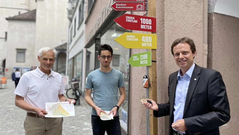 Peter Bänziger, Leiter der Sportfachstelle Chur, Conradin Meili, Projektleiter OL-Postennetz, und Stadtrat Patrik Degiacomi (v.l.) zeigen einen Posten in der Altstadt.