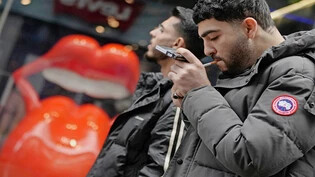 In der Hektik des Alltags: Ein junger Mann zündet sich in den Strassen der britischen Millionenmetropole London eine Zigarette an. 