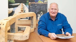 Macht sich für Zusammenarbeit stark: Marcel Lerch. Geschäftsführer von Graubünden Holz, präsentiert die beschlossenen Massnahmen, welche die links und hinter ihm symbolisch dargestellte Holzkette stärken sollen. 